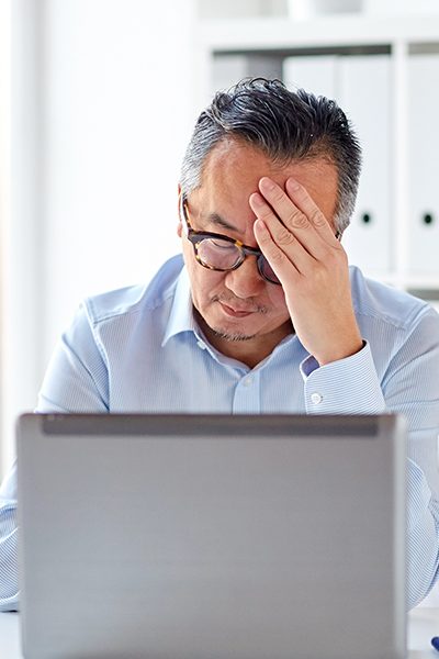 man looking at laptop with hand on forehead round rock tx